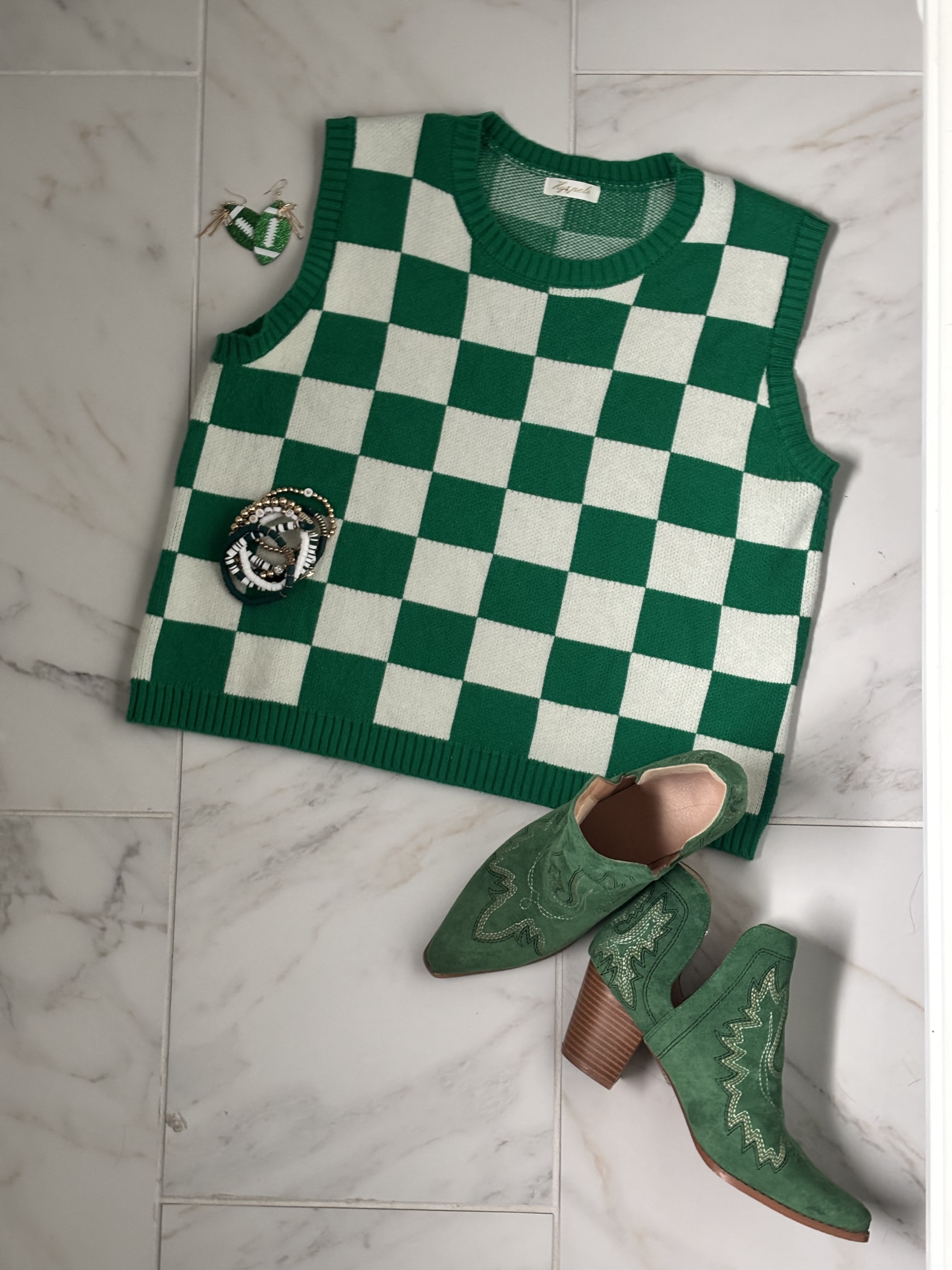 Top view of kelly green checkered sweatervest and green short cowboy booties.