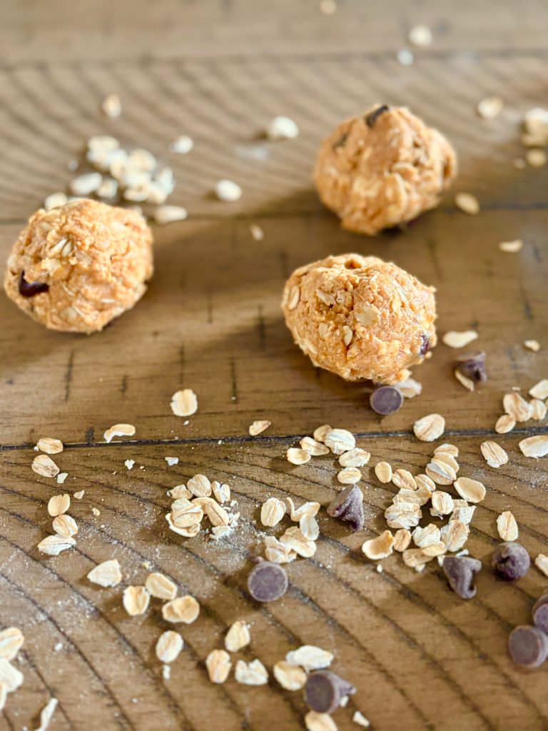 Side view of protein balls with oats and chocolate chips on a table.