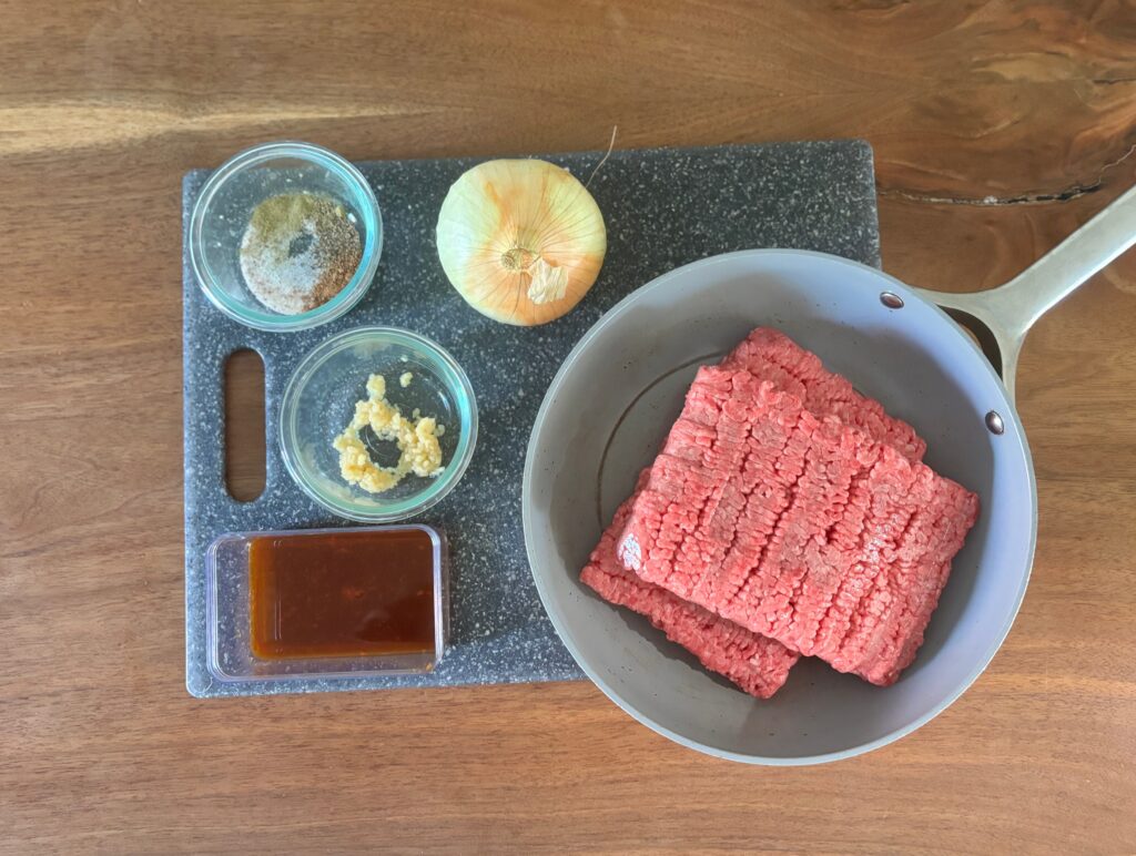 Top-down view of the meat mixture ingredients for beef and cauliflower shepherd's pie that includes garlic and homemade Worcestershire sauce.