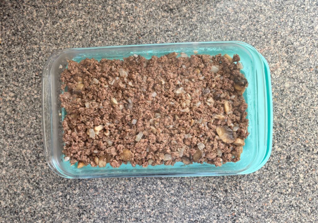 Top-down view of meat mixture inside a glass 9x13 backing dish.