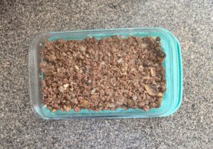 Top-down view of meat mixture inside a glass 9x13 baking dish for shepherd's pie.