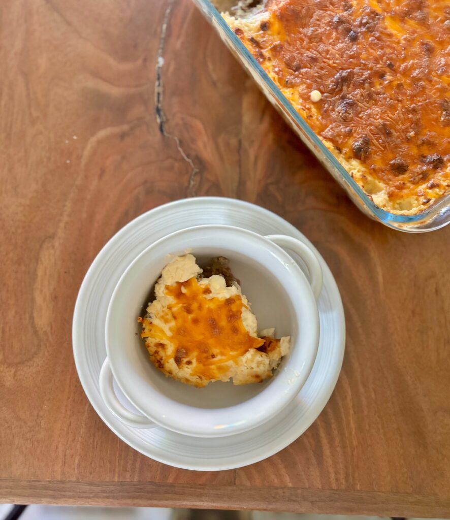 Top down view of shepherds pie in a bowl with cheese, meat and more.