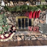 Front facing view of a fireplace with a wood mantel and a tree with pine garland on the mantel.