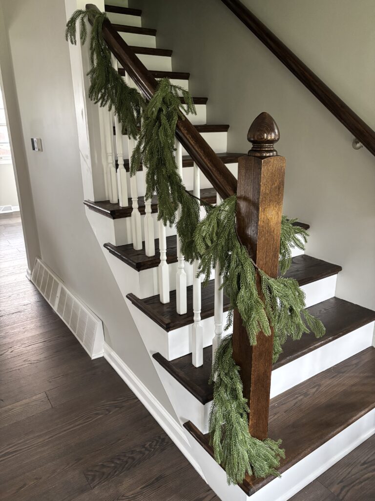Pine garland wrapped around the staircase banister and railing.