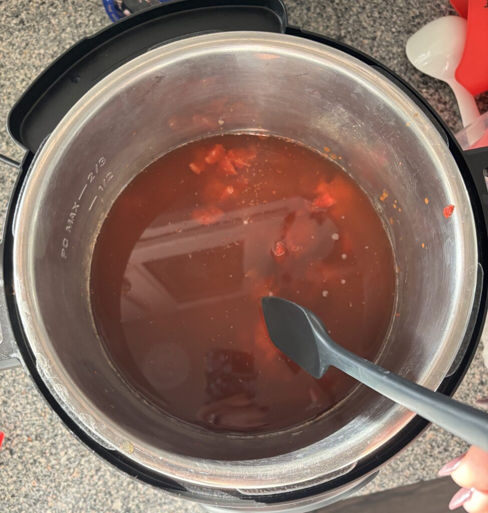 Top-down view of all low-carb easy chili ingredients combined in an Instant Pot, ready to be simmered together. 