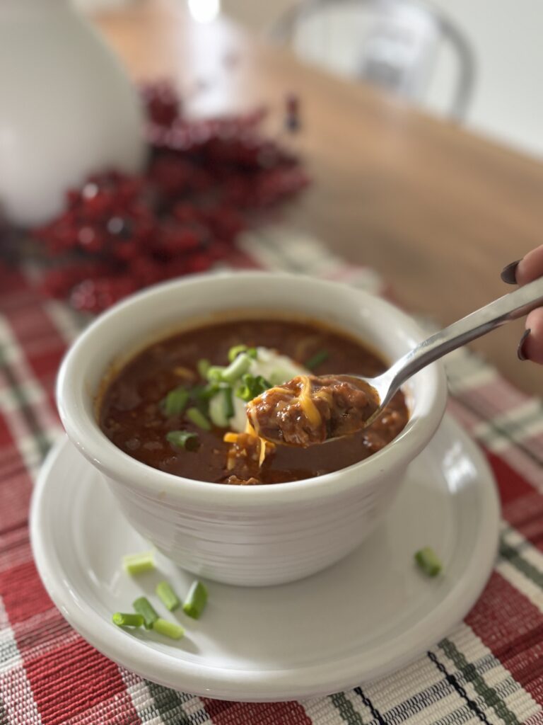 Side view of low-carb chili in a bowl with a spoon, preparing for a bite!